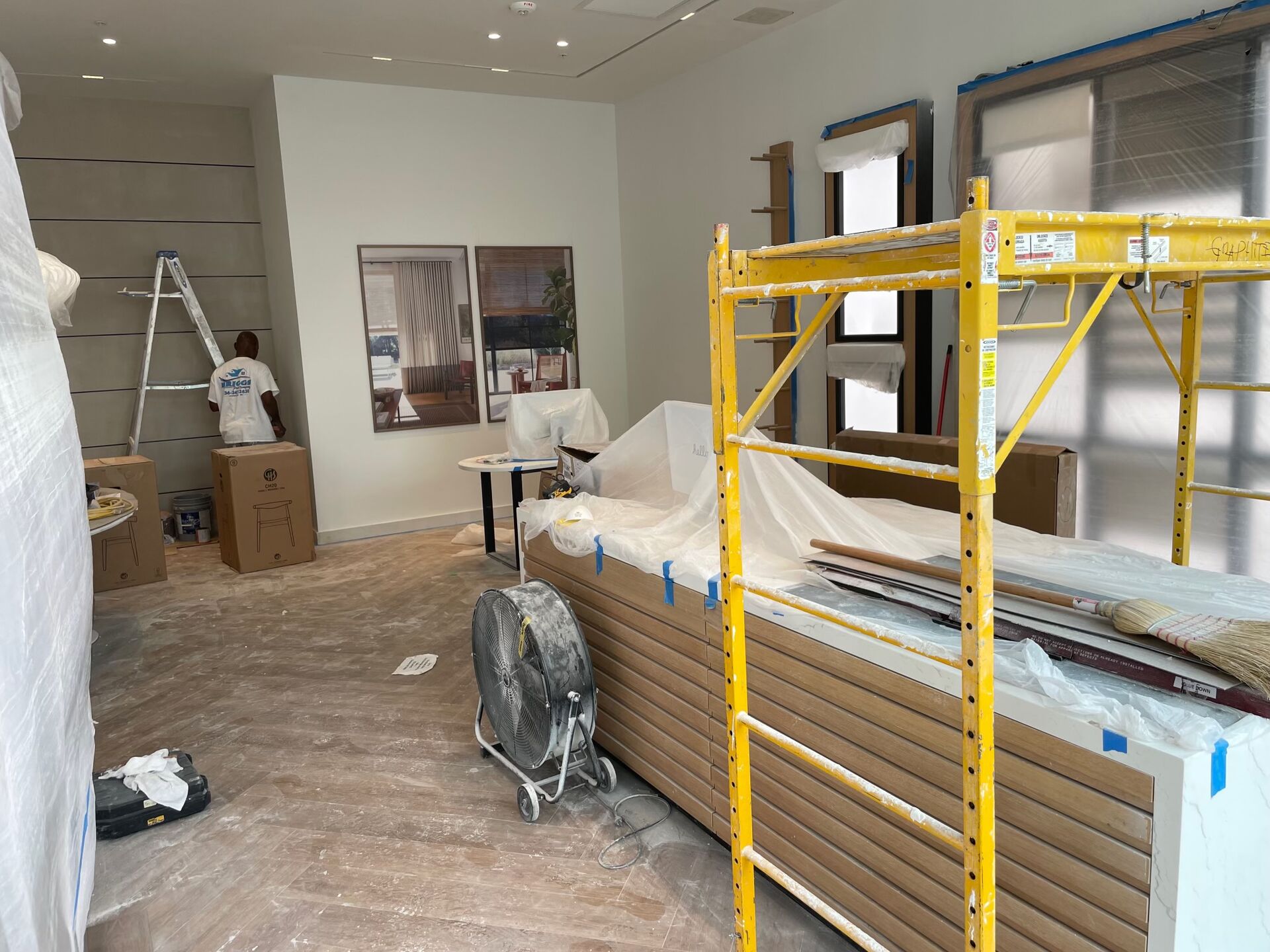 Retail store construction — interior drywall and finishes underway with scaffolding on site